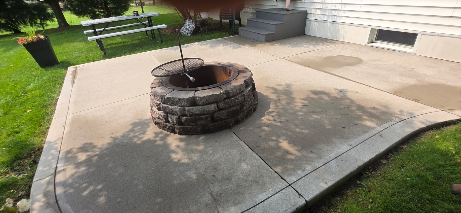 Washed concrete patio around a stone fire pit